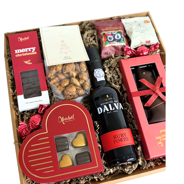 En gavekurv fyldt med julehygge, Dalva portvin, marcipan, fyldte chokolader og klassiske bolsjer.
