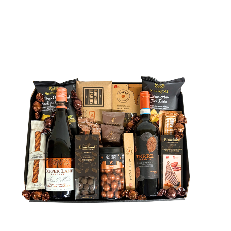 En julekurv fyldt med ren forkælelse,  rødvin, Lakrids by Bülow og udvalgte produkter fra danske producenter.