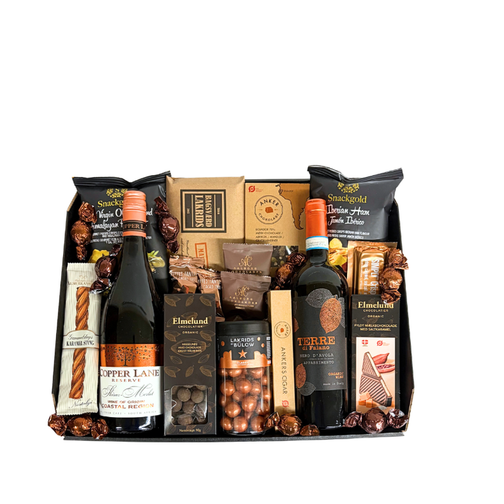 En julekurv fyldt med ren forkælelse,  rødvin, Lakrids by Bülow og udvalgte produkter fra danske producenter.