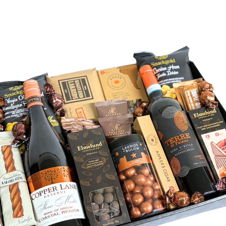 En julekurv fyldt med ren forkælelse,  rødvin, Lakrids by Bülow og udvalgte produkter fra danske producenter.