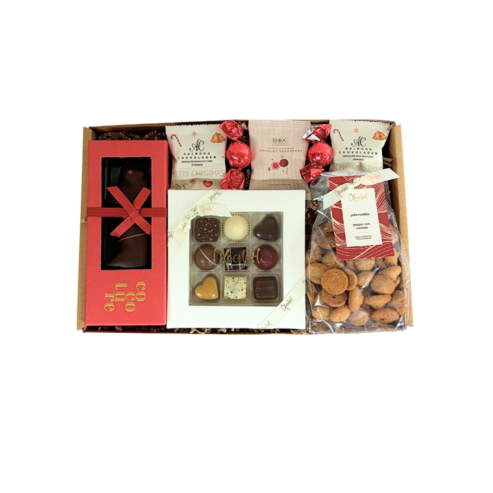En julegave fyldt med søde favoritter , fyldte chokolader, sprøde vaniljekranse, smørbagte pebernødder, marcipangris