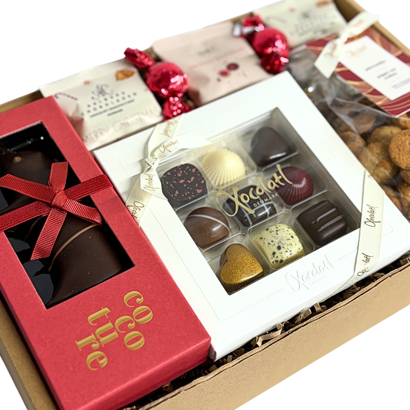 En julegave fyldt med søde favoritter , fyldte chokolader, sprøde vaniljekranse, smørbagte pebernødder, marcipangris