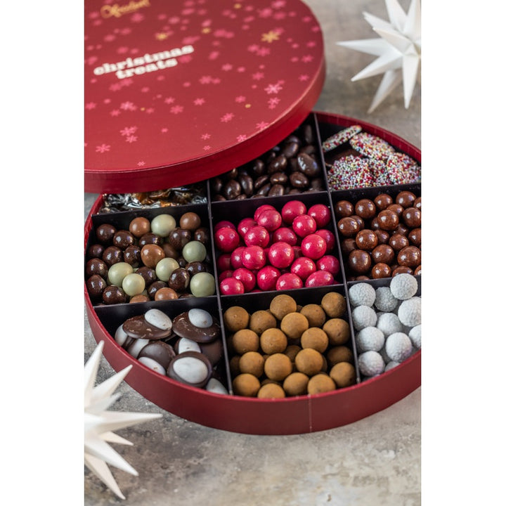 Xocolatl chokolade og dragéer i rummene i en rund rød æske